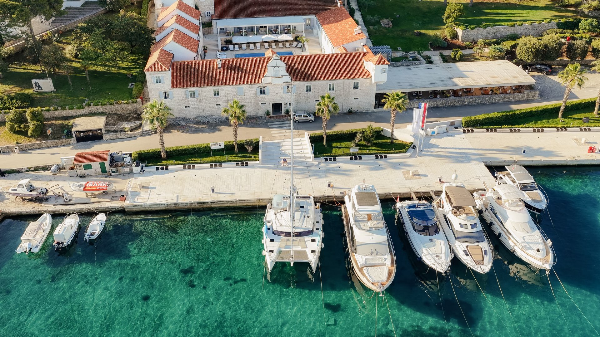 Katamaran und Yachten am historischen Schloss Martinis Marchi in Maslinica auf der Insel Šolta
