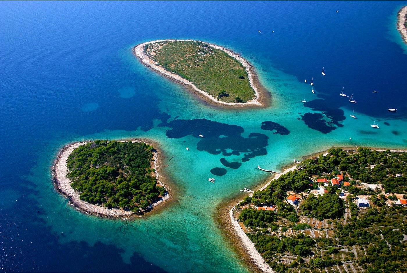 Luftaufnahme der Blauen Lagune bei Trogir mit türkisblauem Wasser, kleinen Inseln und ankernden Segelyachten