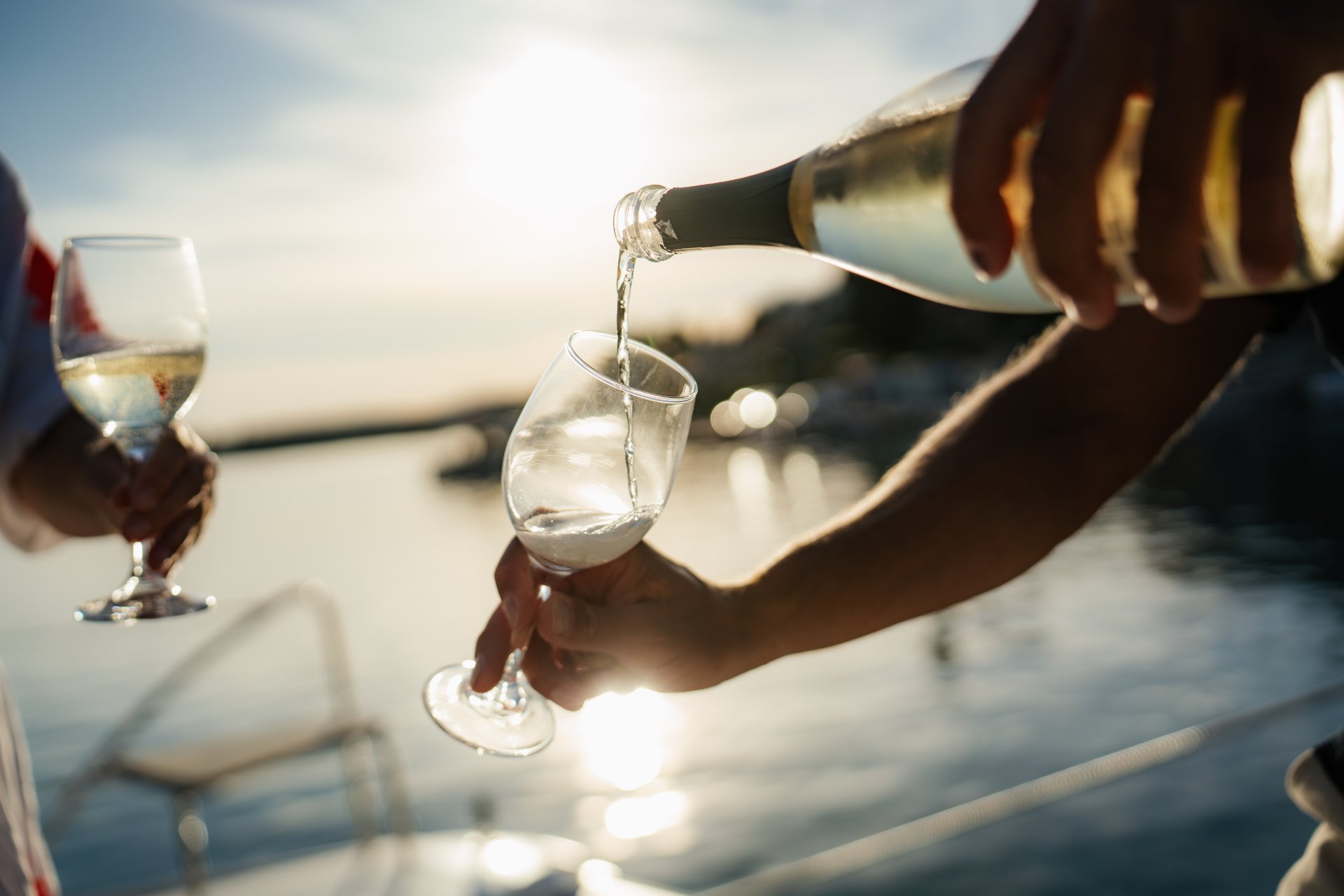 Gäste geniessen ein Glas Wein an Bord eines Katamarans in Kroatien.