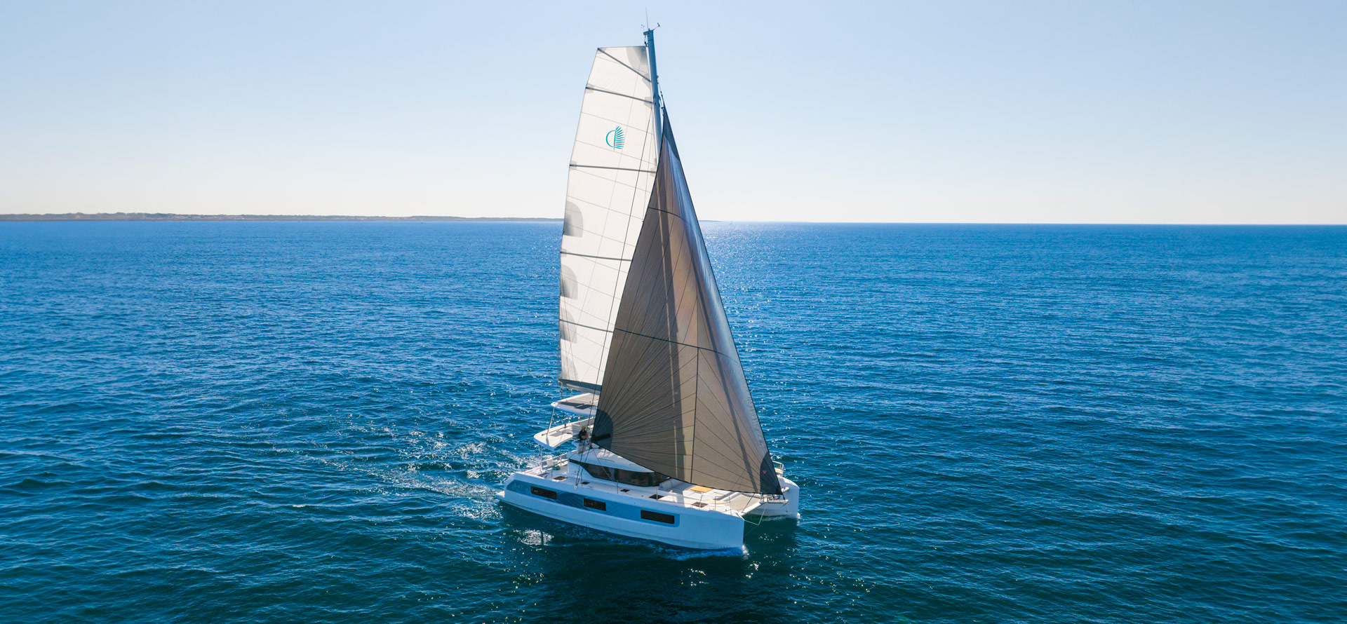 Ein Katamaran Lagoon 47 unter Segeln auf dem Meer.