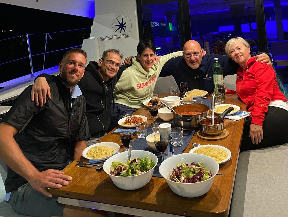 Crew eines Katamarans beim Essen vor Anker Crew eines Katamarans beim Essen vor Anker